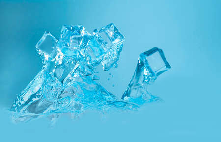 Concept of ice cubes with splashing water on blue background.の写真素材
