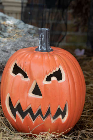 Funny face pumpkin on straw in grunge Halloween background.の写真素材