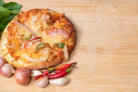 Pizza on wooden board with fresh peppers and basil with garlic on copy space background for text on various important occasionsの写真素材