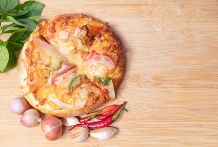 Pizza on wooden board with fresh peppers and basil with garlic on copy space background for text on various important occasionsの写真素材