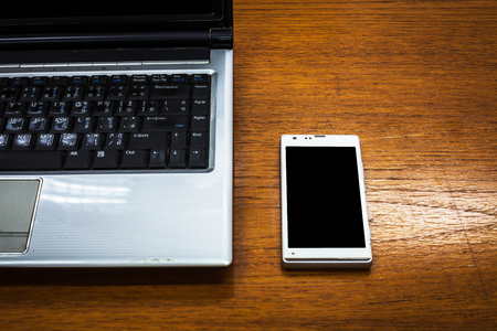 close up of the mobile phone near the laptopの写真素材