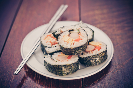 Close up of Rolled sushi rice on a white dish , Dark Vintage color filterの写真素材