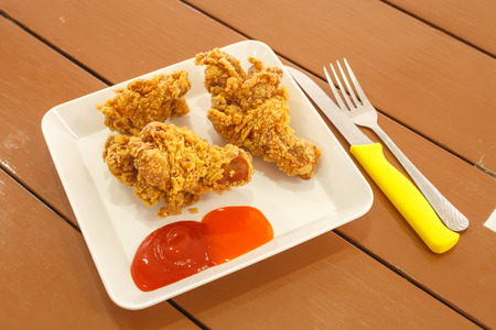Fried chicken leg, Place a plate on white table in a restaurant.の写真素材