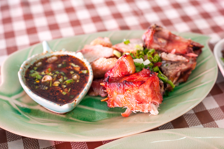 Grilled pork neck with dipping sauce in a northern Thai restaurant.の写真素材
