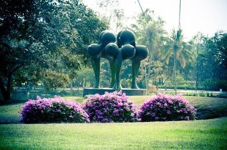 purple bougainvillea and sculpture on evening in the parkの写真素材
