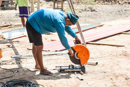 PHITSANULOK - MAY 14: The smith are cutting steel with electric saw. on May 14, 2016 in Phitsanulok, Thailand.のeditorial素材