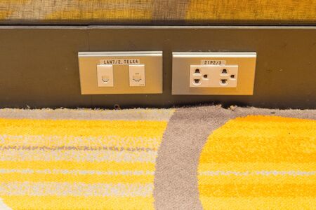 Close up power outlet and telephone outlet and computer outlet in a socket