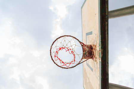 Outdoor basketball hoop with blue sky and cloudsの写真素材