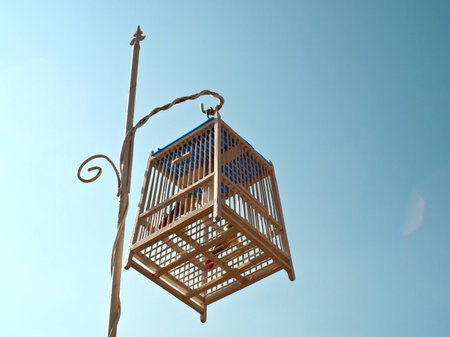 Bird cage hanging on a pole の写真素材