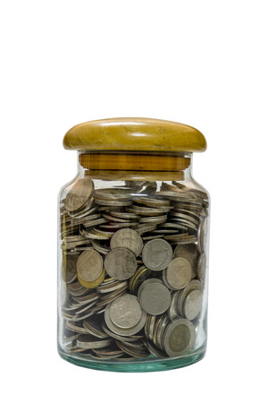 Glass bottle full of coins on white の写真素材