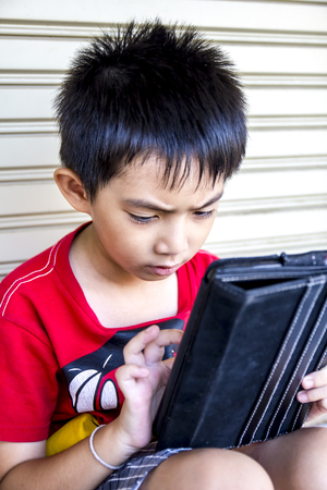 Young asian boy use to tablet の写真素材