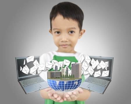 young boy holding world and show laptop send letter の写真素材