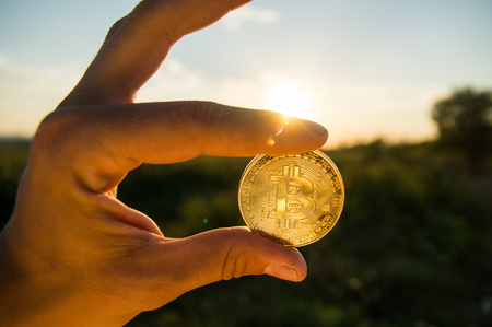 HAND HOLDING BITCOIN CRYPTO CURRENCYの写真素材