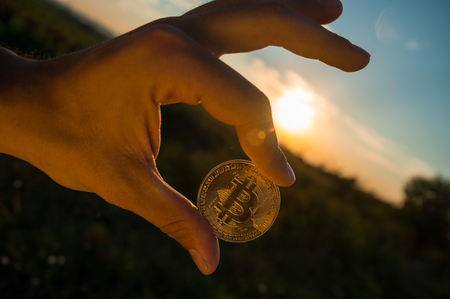 HAND HOLDING BITCOIN CRYPTO CURRENCYの写真素材