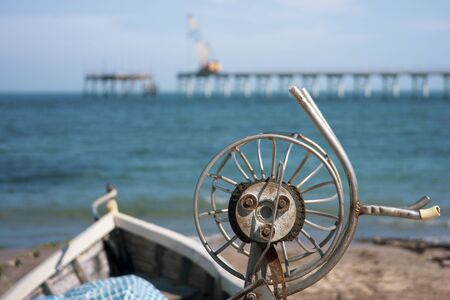 Boat with mussels and oyster container with a fishing pier in the backgroundの写真素材