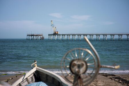 Boat with mussels and oyster container with a fishing pier in the backgroundの写真素材