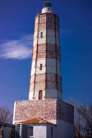 Big Lighthouse isolated on clear blue sky and one cloudの写真素材