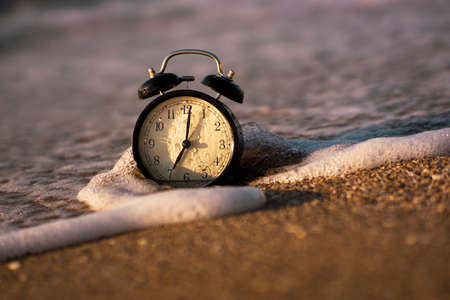 Alarm clock splashing in the beach water