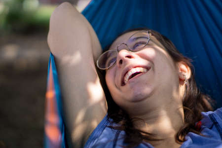 Beautiful pregnant girl smiling and being happy in a hammockの写真素材