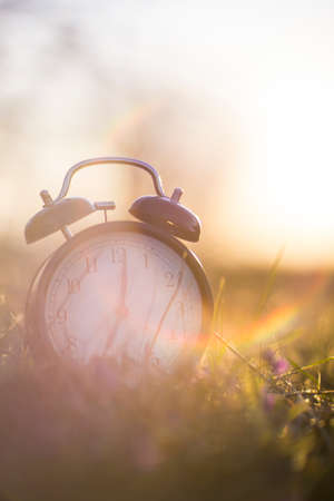 ALARM CLOCK ON SUNRISE MORNING WITH LIGHT FLARESの写真素材