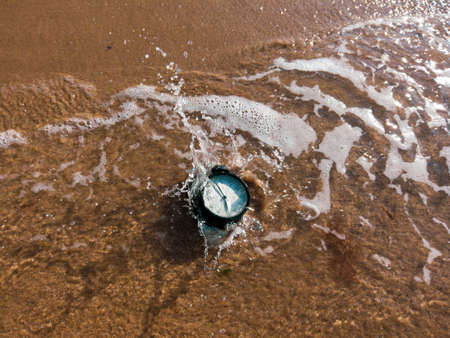 Alarm clock splashing in the beach waterの写真素材