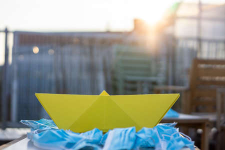 Pollution from masks with a paper boat concept art. Sea of masks.の写真素材