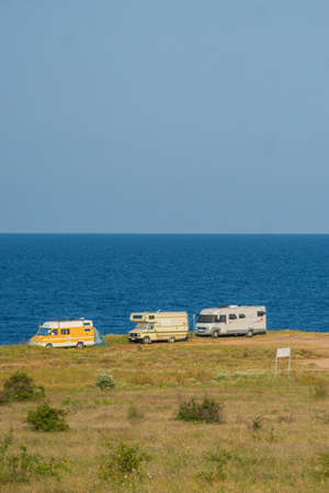 MULTIPLE OLD CARAVANS CAMPING AT THE SEA COAST