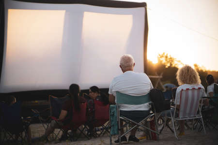 Old couple at a beach cinema on sunsetの写真素材