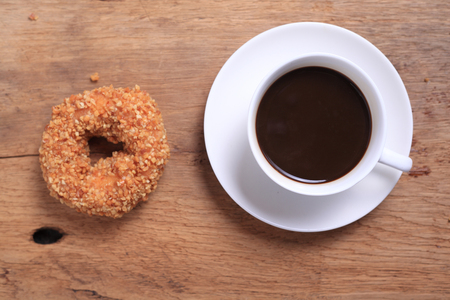 fresh donut with coffee cup on wooden table topの写真素材