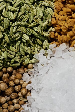 A selection of four spices - Salt, Corriander Seeds, Fenugreek Seeds & Fennel Seedsの写真素材