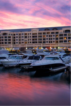 Luxury boats in the marina at sunset with luxury apartments in the background.の写真素材