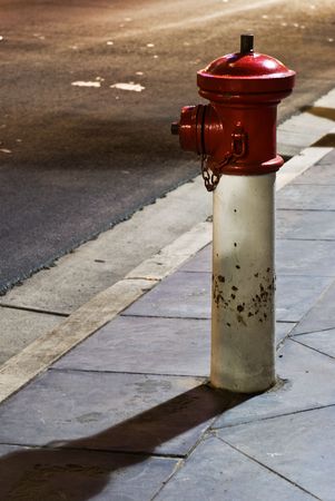 A red fire hydrant on the footpath taken at night.の写真素材
