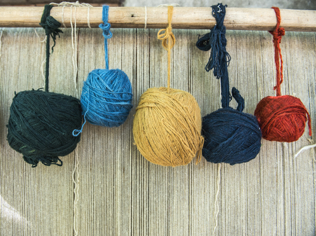 Naturally dyed balls of yarn in white, red, blue, yellow and greenの写真素材