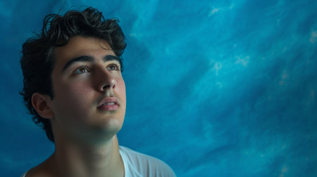young man in a contemplative pose, surrounded by a cool blue background, generative aiの素材