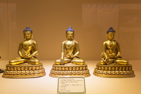 Singapore city, Singapore - April 11 2015: Three golden Buddha statues in showcase at Buddha Tooth Relic Temple and Museum, Chinatown.のeditorial素材