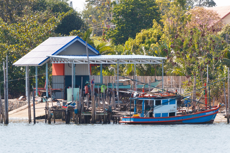 Old native fishery boat floating on the sea near small harbor at Rayong, Thailand.の写真素材
