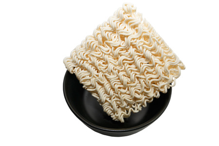 Fried instant noodle in black bowl on white background, Isolated.の写真素材