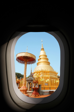 Aerial view of airplane window, golden pagoda at Wat Phra That Doi Suthep, Chiangmai Thailand.の写真素材