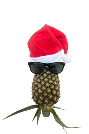 Pineapple wearing Santa hat and sunglasses on white background, Isolated.の写真素材