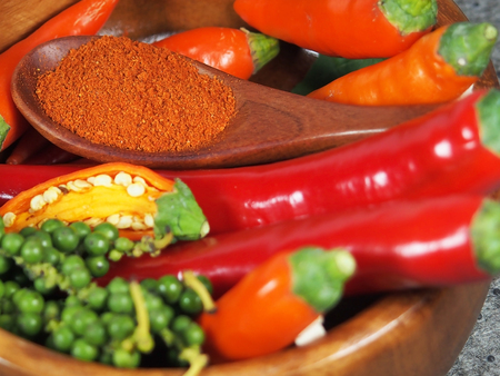 Red hot chilli pepper in wooden spoon on tableの写真素材