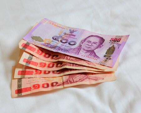 Thai bank note and Thai bank note on the bed sheetの写真素材