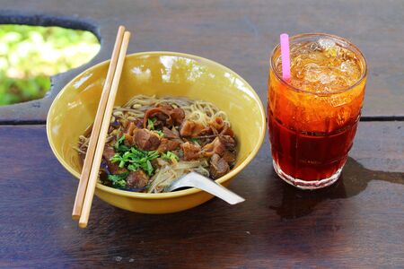 Noodles with pork with soup Thai style and ice tea. Thai peoples call braised pork Noodles or Moo toonの写真素材