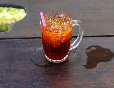 ice tea with ice on wooden tableの写真素材