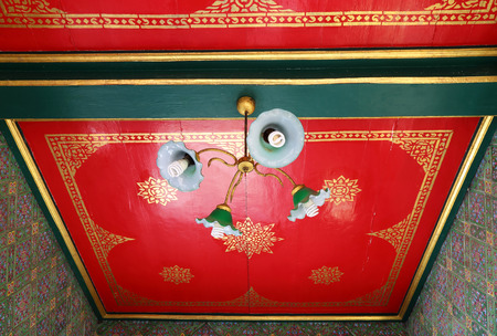 light lamp hang on ceiling red background in thailand templeの写真素材
