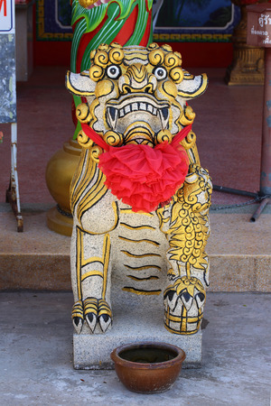 Chinese lion statue with red ribbon in the Chinese Shrineの写真素材
