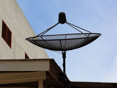 Satellite dish on roof house in the dayの写真素材