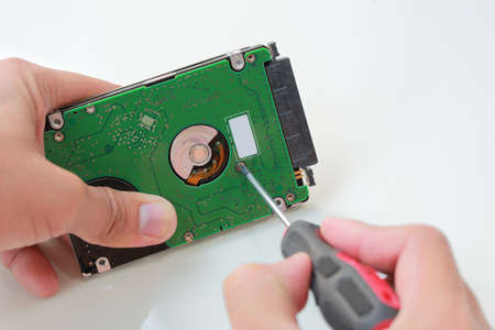 Man hand with screwdriver fixing or repairing the hard driveの写真素材
