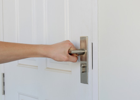 man's hand close the white door