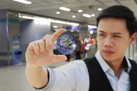 businessman' hand  holding and see the future earth concept on subway station background - Elements of this image furnished by NASAの写真素材