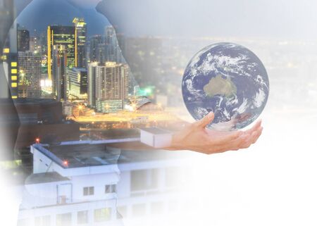 Double exposure of man holding the world on city blured background  - Elements of this image furnished by NASAの写真素材